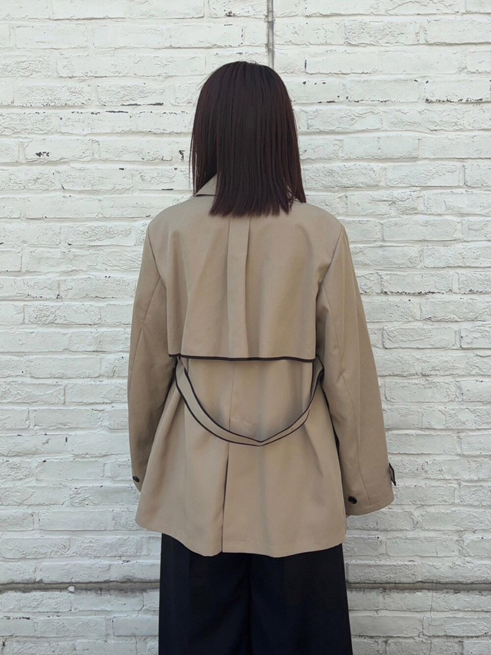 ベージュ系のトレンチコートを着用したレディースの春コーディネートの6枚目の写真