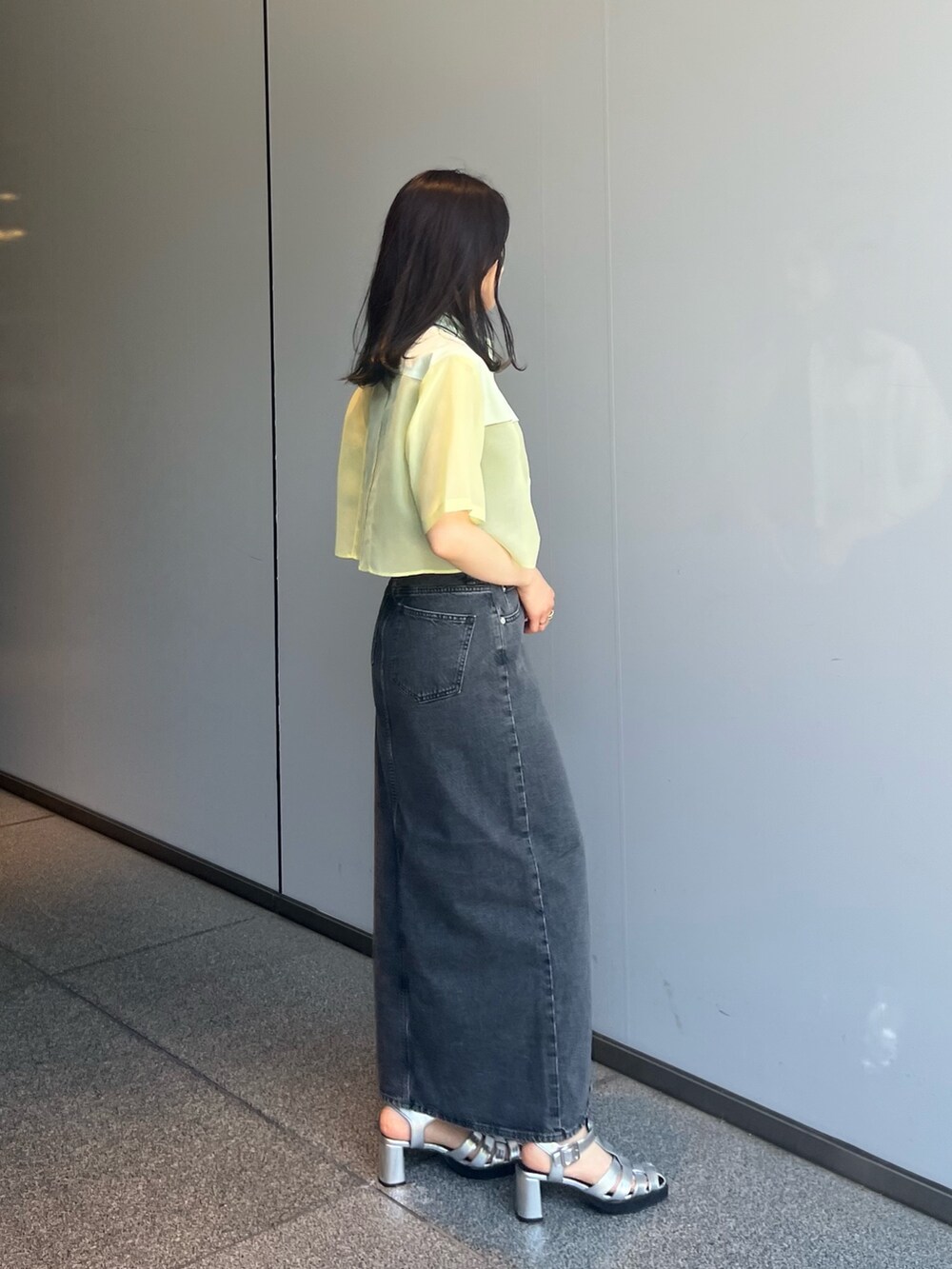 ブラック系のデニムスカート、グリーン系のシャツ/ブラウスを着用したレディースの夏コーディネートの3枚目の写真