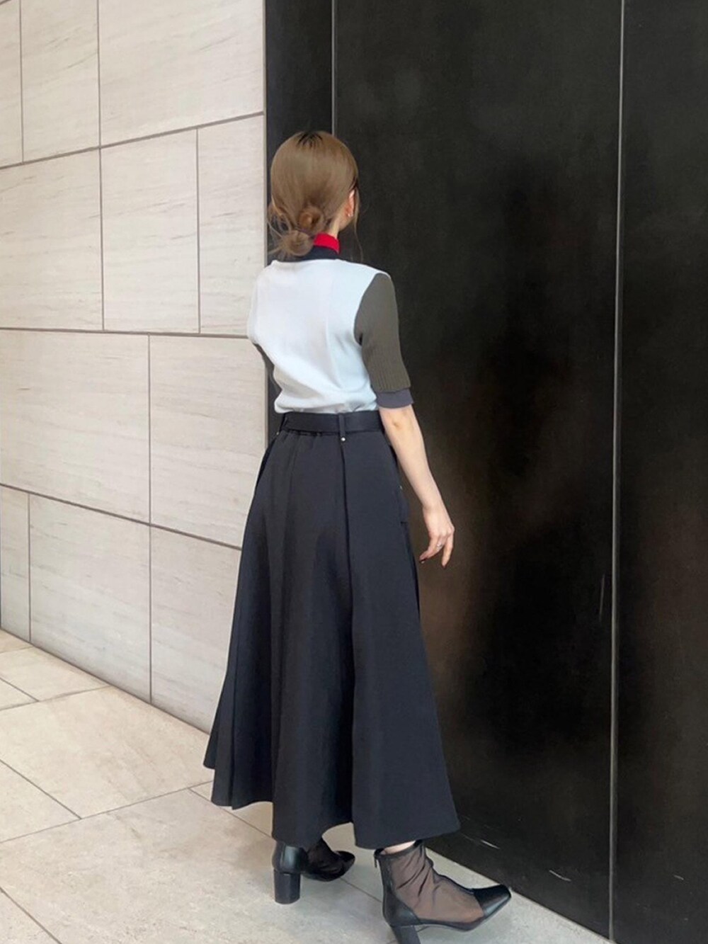 グレー系のニット/セーター、ブラック系のスカートを着用したレディースの春コーディネートの3枚目の写真