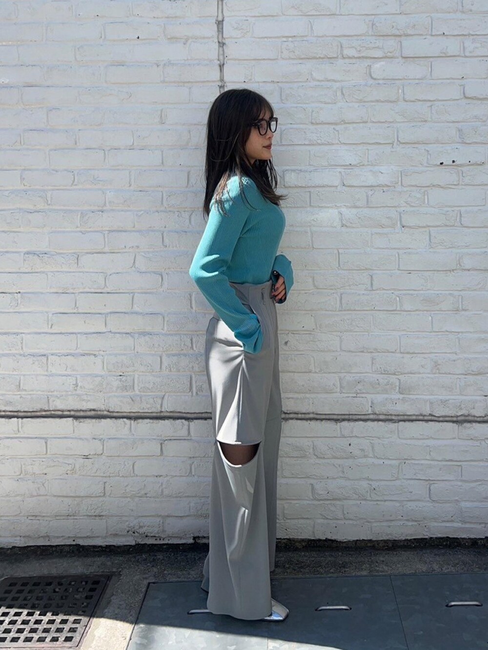 ブルー系のニット/セーター、グレー系のその他パンツを着用したレディースの春コーディネートの4枚目の写真