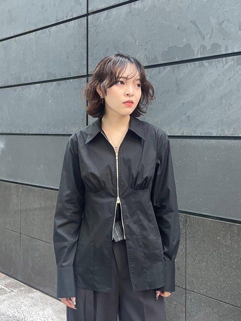 ブラック系のシャツ/ブラウス、グレー系のスラックスを着用したレディースの秋コーディネートの4枚目の写真