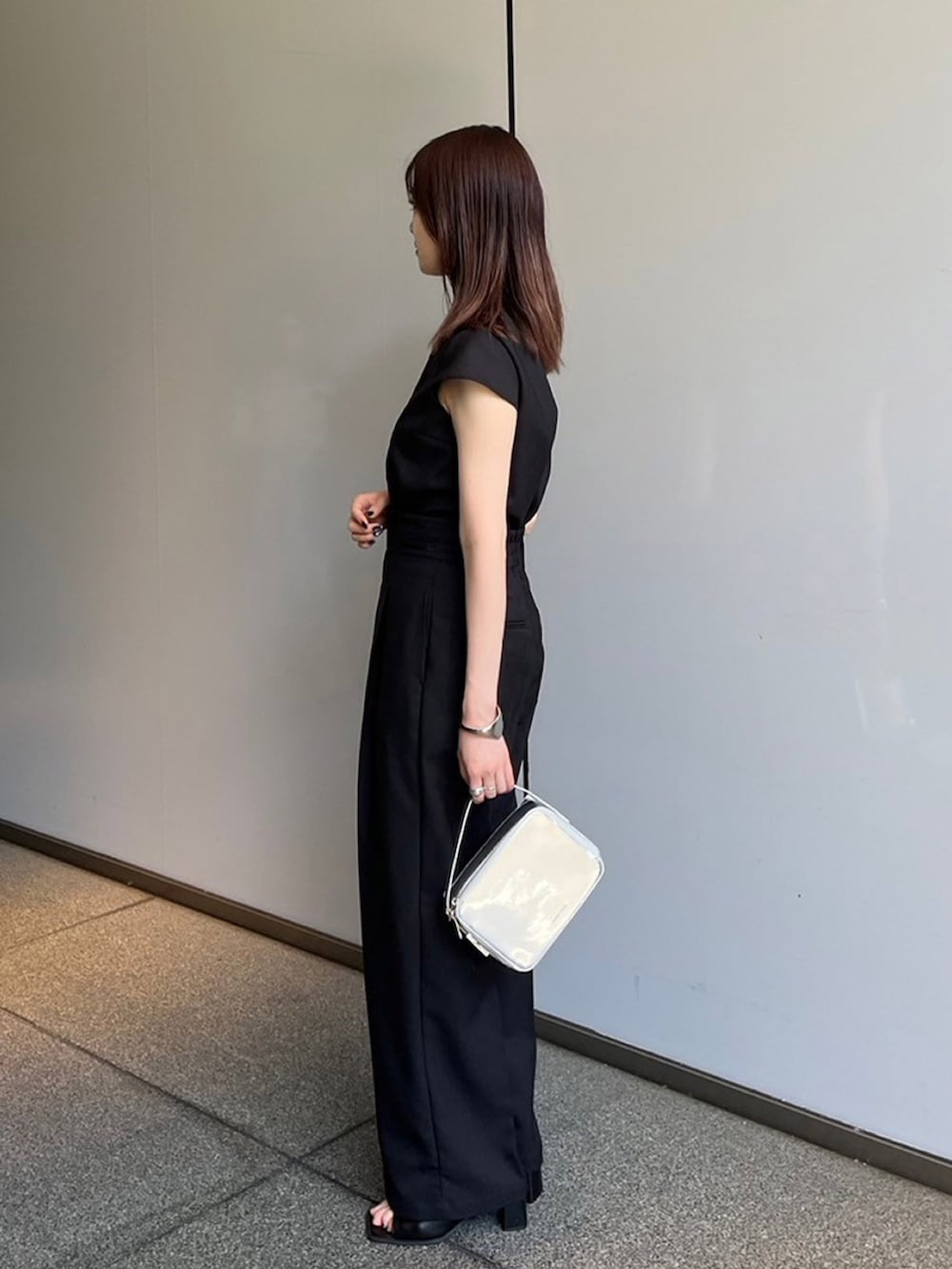 ブラック系のシャツ/ブラウス、ブラック系のスラックスを着用したレディースの夏コーディネートの3枚目の写真