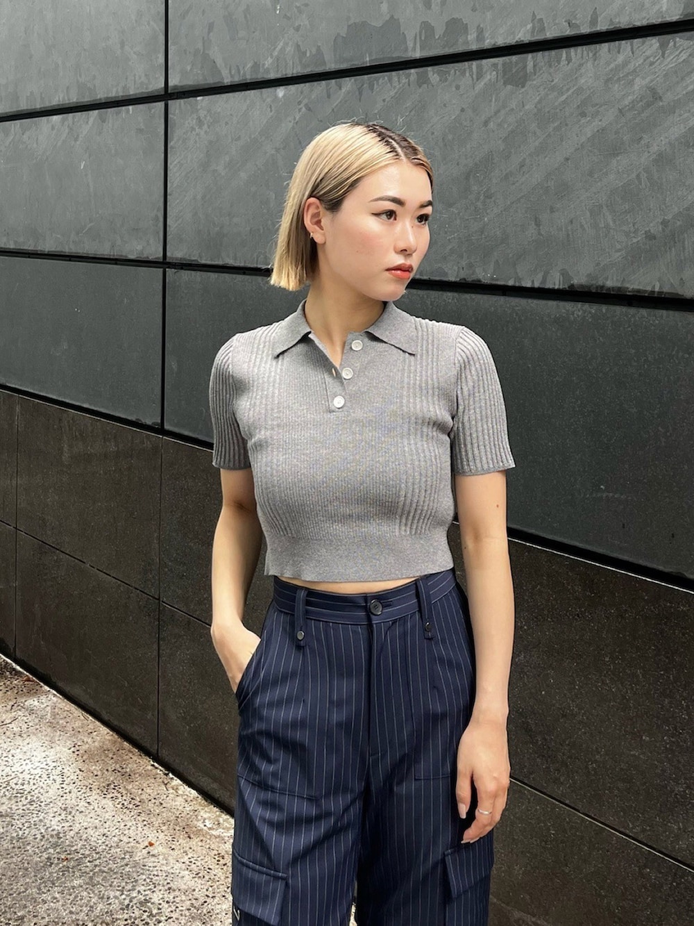 グレー系のポロシャツ、ブルー系のカーゴパンツを着用したレディースの夏コーディネートの4枚目の写真