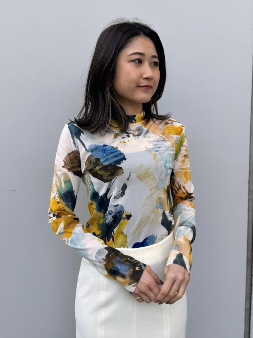 イエロー系のTシャツ/カットソー、ホワイト系のスカートを着用したレディースの冬コーディネートの5枚目の写真