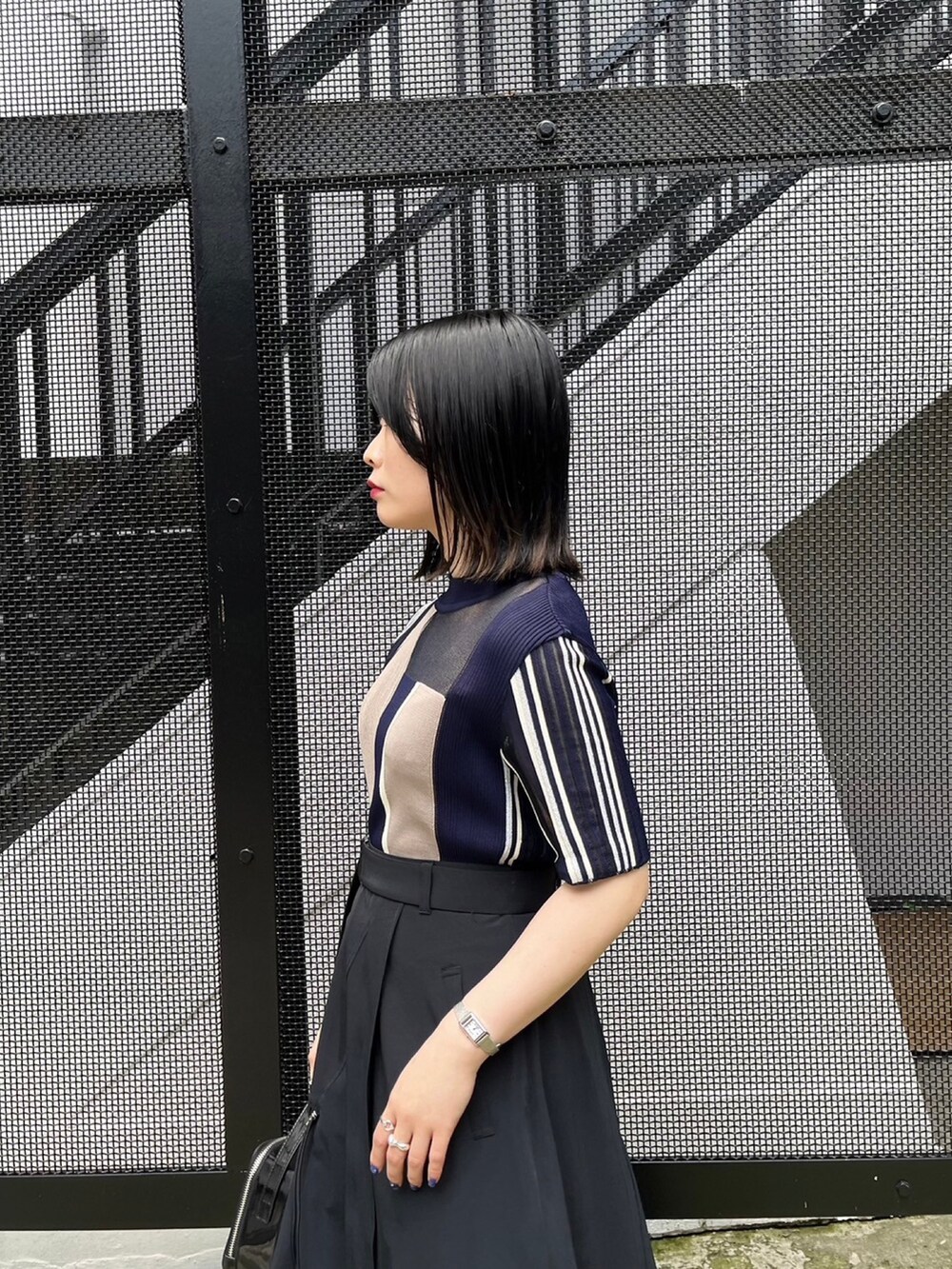 ブルー系のニット/セーター、ブラック系のスカートを着用したレディースの春コーディネートの4枚目の写真