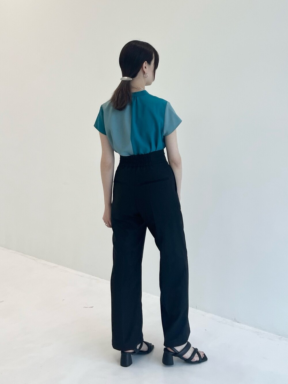 グリーン系のシャツ/ブラウス、ブラック系のスラックスを着用したレディースの夏コーディネートの3枚目の写真