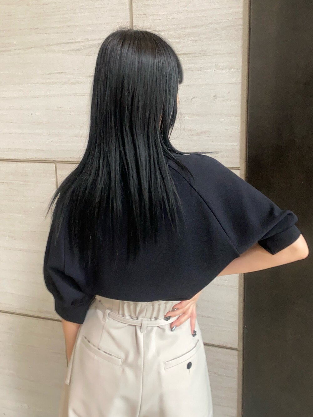 ブラック系のニット/セーター、グレー系のスラックスを着用したレディースの春コーディネートの4枚目の写真