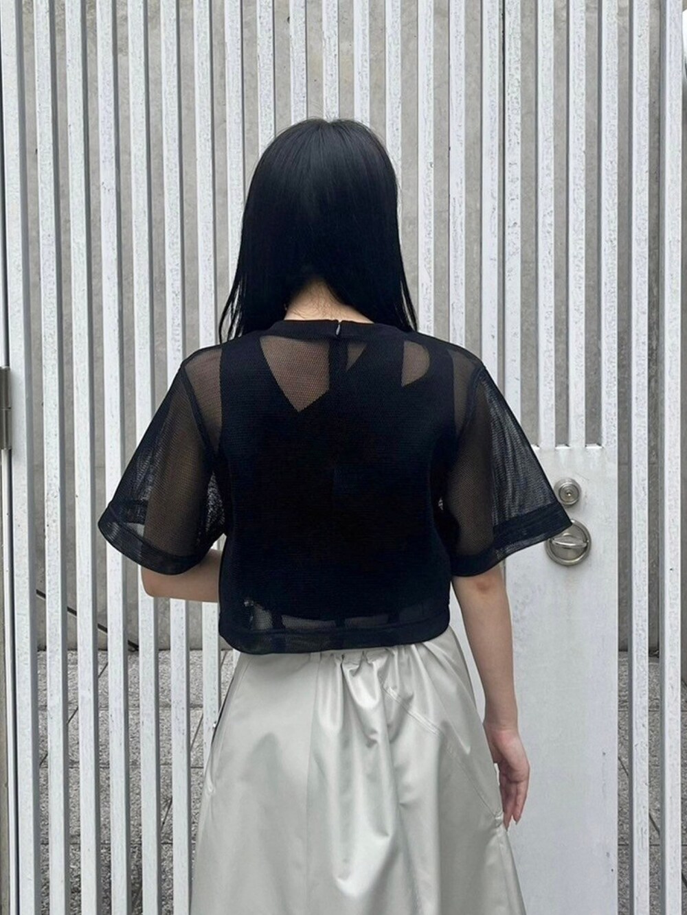 ブラック系のシャツ/ブラウス、ベージュ系のスカート、ブラック系のタンクトップを着用したレディースの春コーディネートの6枚目の写真