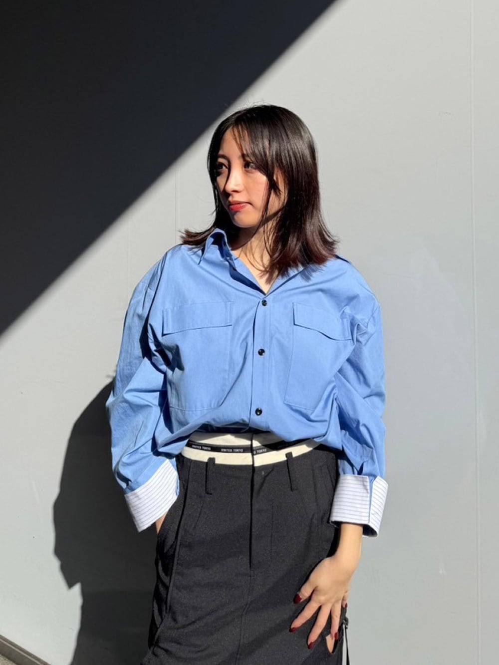 ブラック系のスカート、ブルー系のシャツ/ブラウスを着用したレディースの秋コーディネートの4枚目の写真