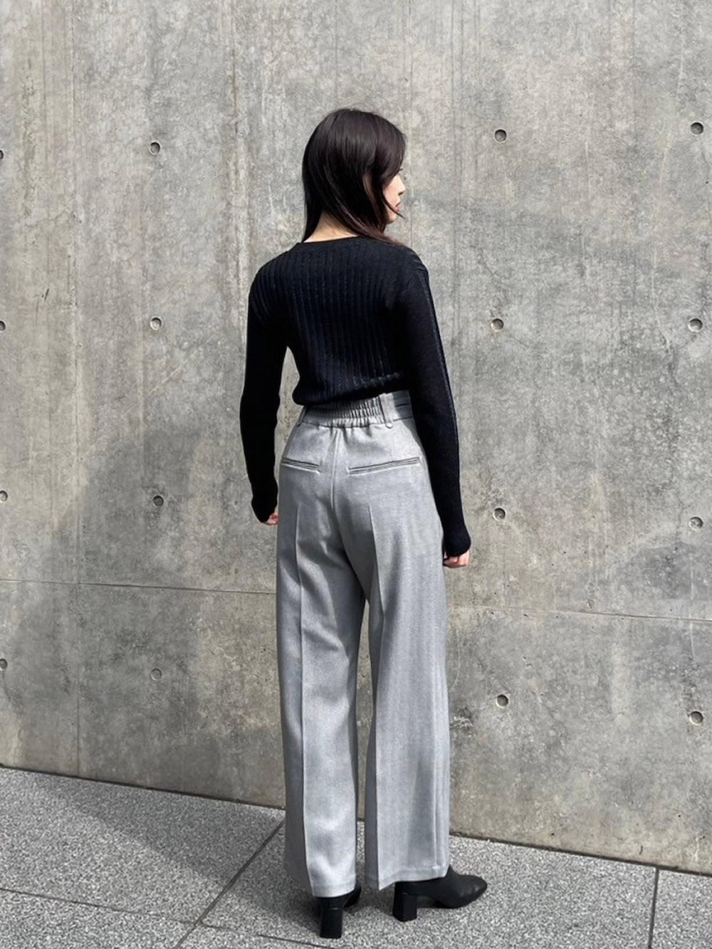 ブラック系のニット/セーター、グレー系のその他パンツを着用したレディースの秋コーディネートの3枚目の写真