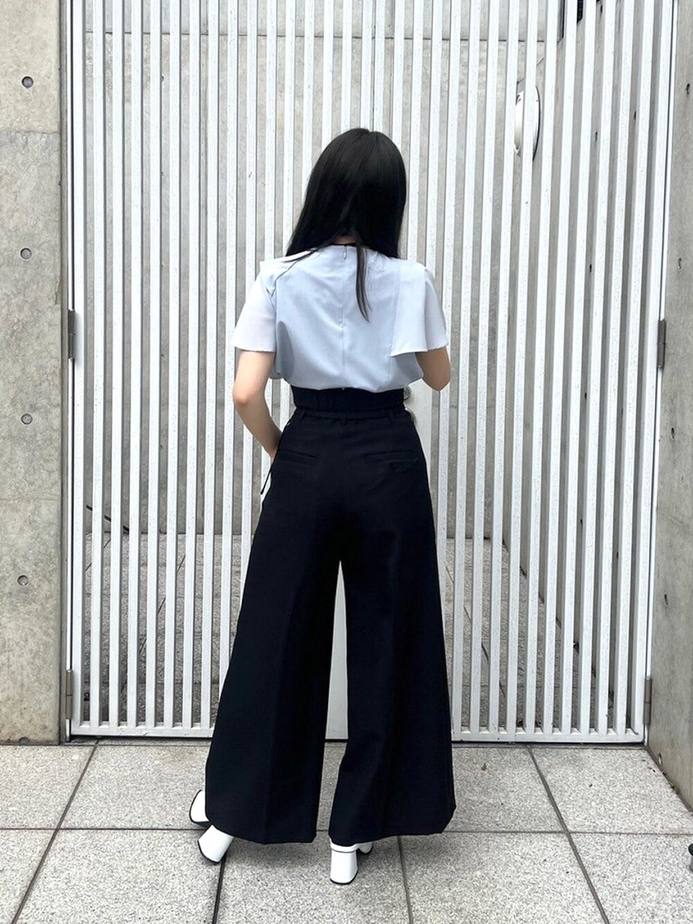 ブルー系のシャツ/ブラウス、ブラック系のスラックスを着用したレディースの春コーディネートの3枚目の写真