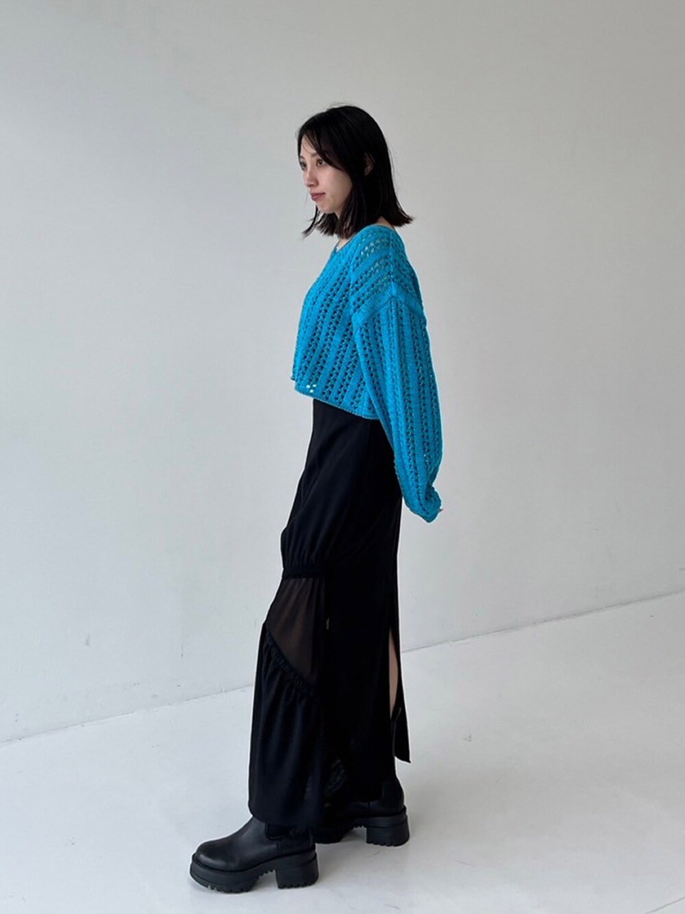 ブルー系のニット/セーター、ブラック系のスカートを着用したレディースの秋コーディネートの2枚目の写真