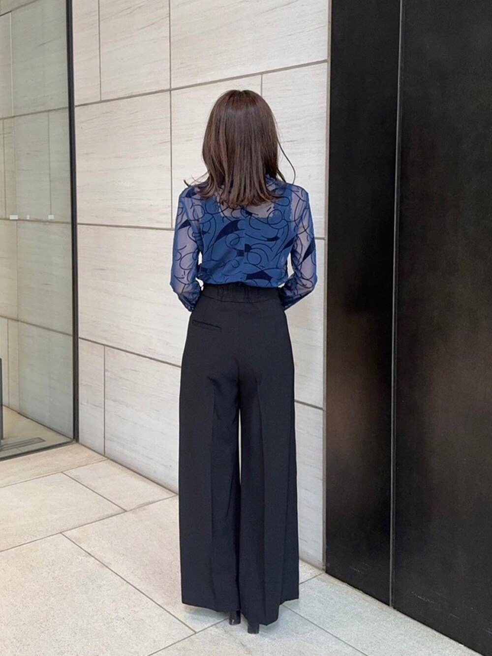 ブルー系のTシャツ/カットソー、ブラック系のスラックスを着用したレディースの春コーディネートの3枚目の写真