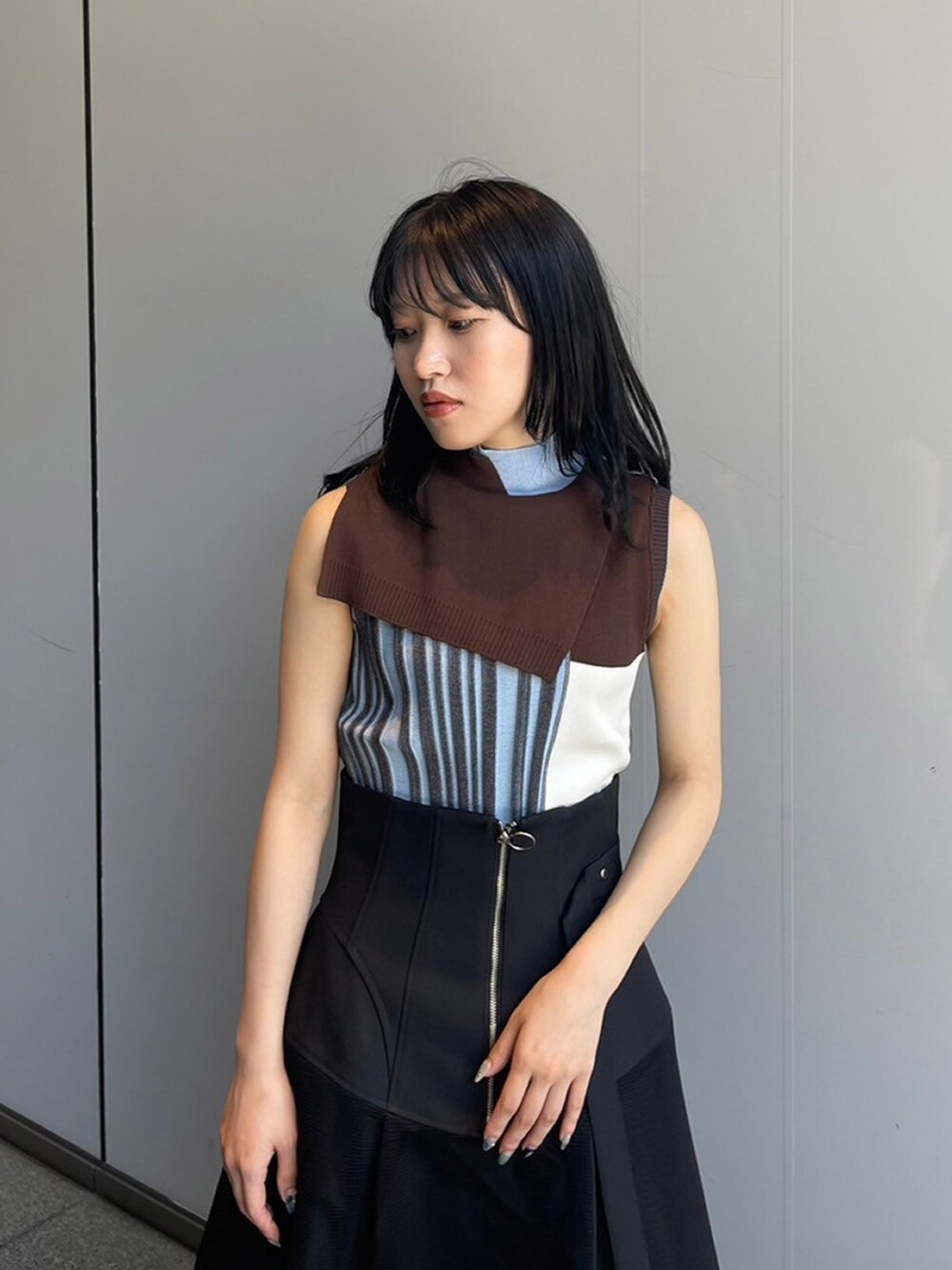 ブルー系のニット/セーター、ブラック系のスカートを着用したレディースの夏コーディネートの3枚目の写真