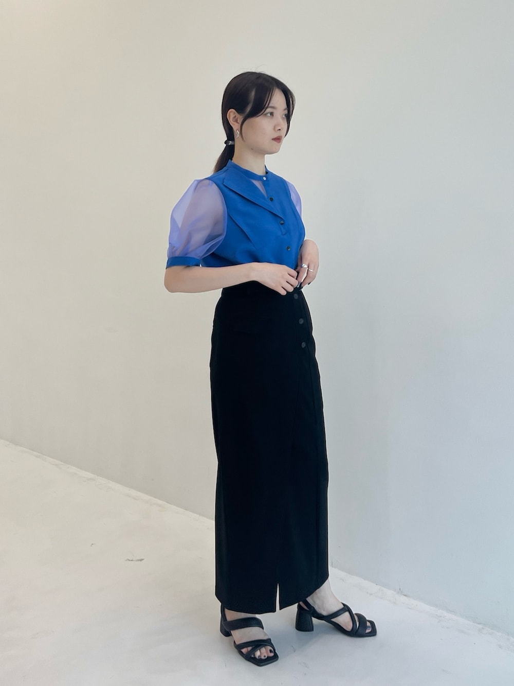 ブルー系のシャツ/ブラウス、ブラック系のスカートを着用したレディースの夏コーディネートの2枚目の写真