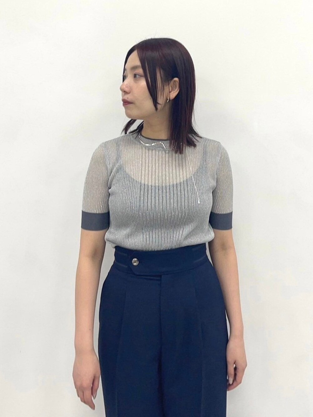 シルバー系のニット/セーター、ブルー系のスラックスを着用したレディースの春コーディネートの5枚目の写真