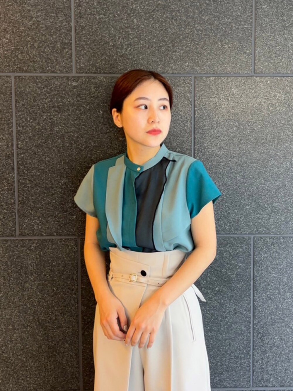 グリーン系のシャツ/ブラウス、グレー系のスラックスを着用したレディースの夏コーディネートの4枚目の写真