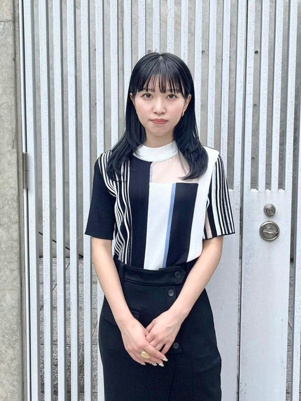 ブラック系のニット/セーター、ブラック系のスカートを着用したレディースの春コーディネートの5枚目の写真