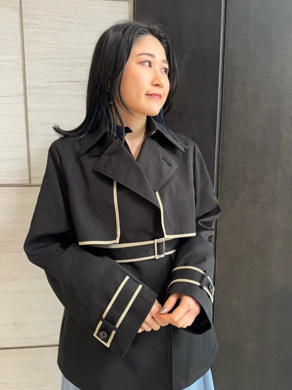 ブラック系のトレンチコートを着用したレディースの春コーディネートの4枚目の写真