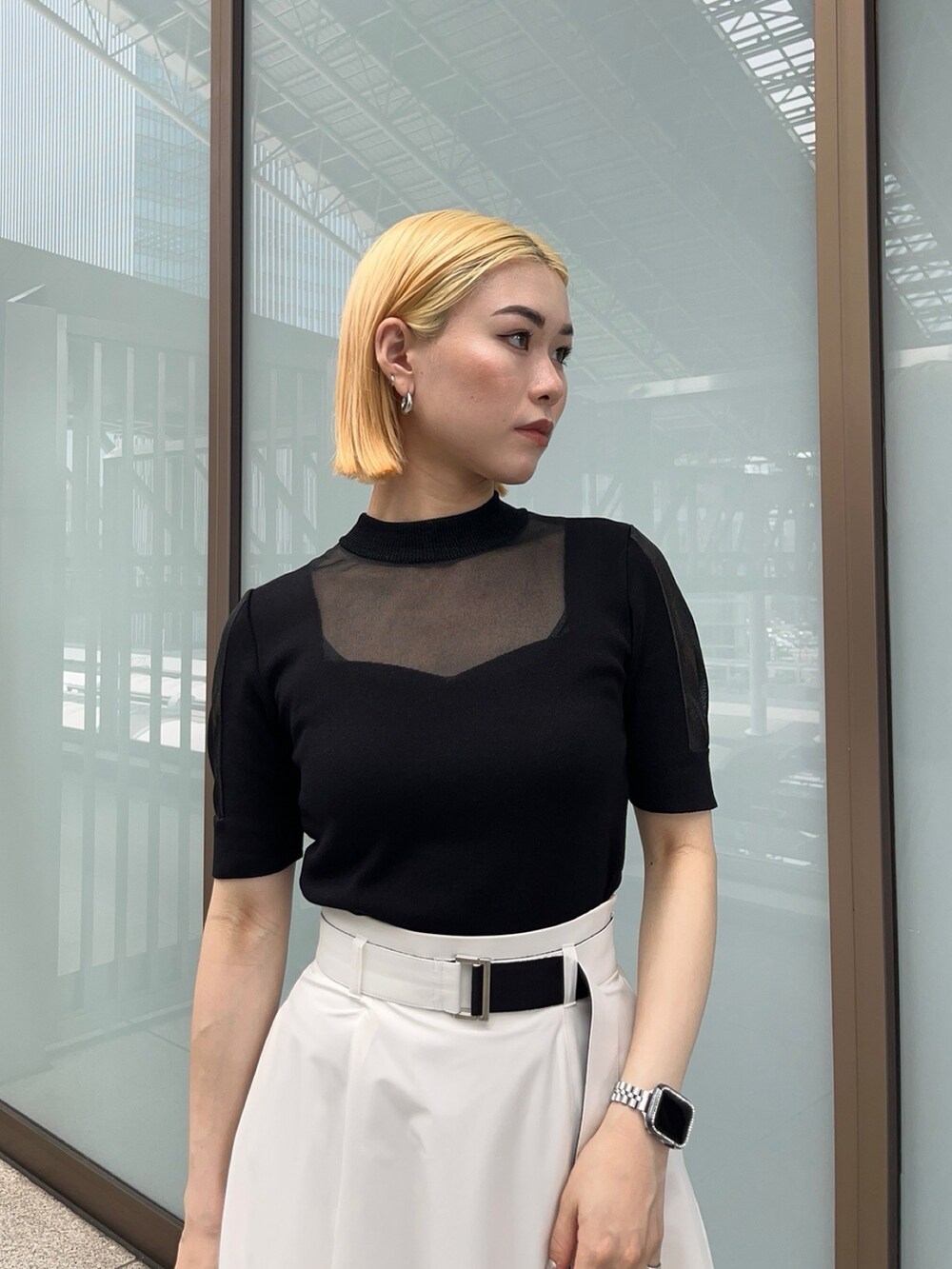 ブラック系のニット/セーター、ホワイト系のスカートを着用したレディースの夏コーディネートの4枚目の写真