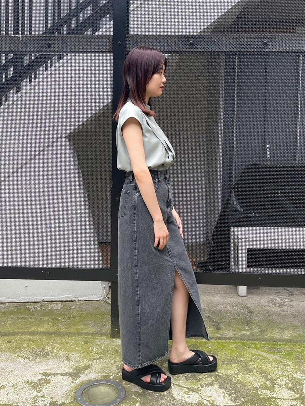 グリーン系のシャツ/ブラウス、ブラック系のデニムスカートを着用したレディースの春コーディネートの4枚目の写真