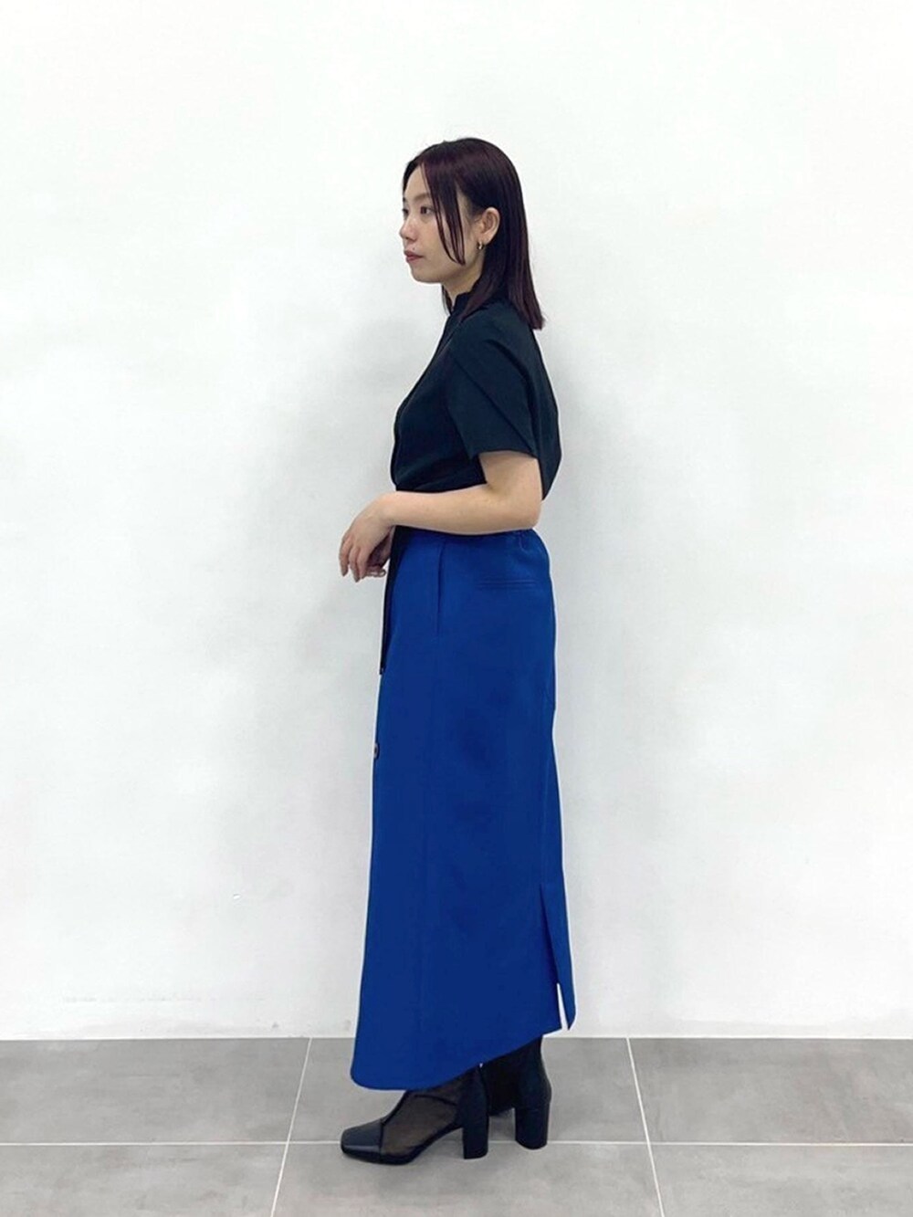 ブルー系のスカート、ブラック系のシャツ/ブラウスを着用したレディースの春コーディネートの2枚目の写真