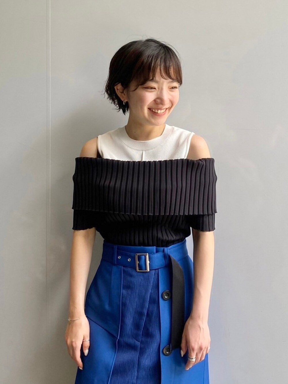 ブラック系のニット/セーター、ブルー系のスカートを着用したレディースの春コーディネートの5枚目の写真