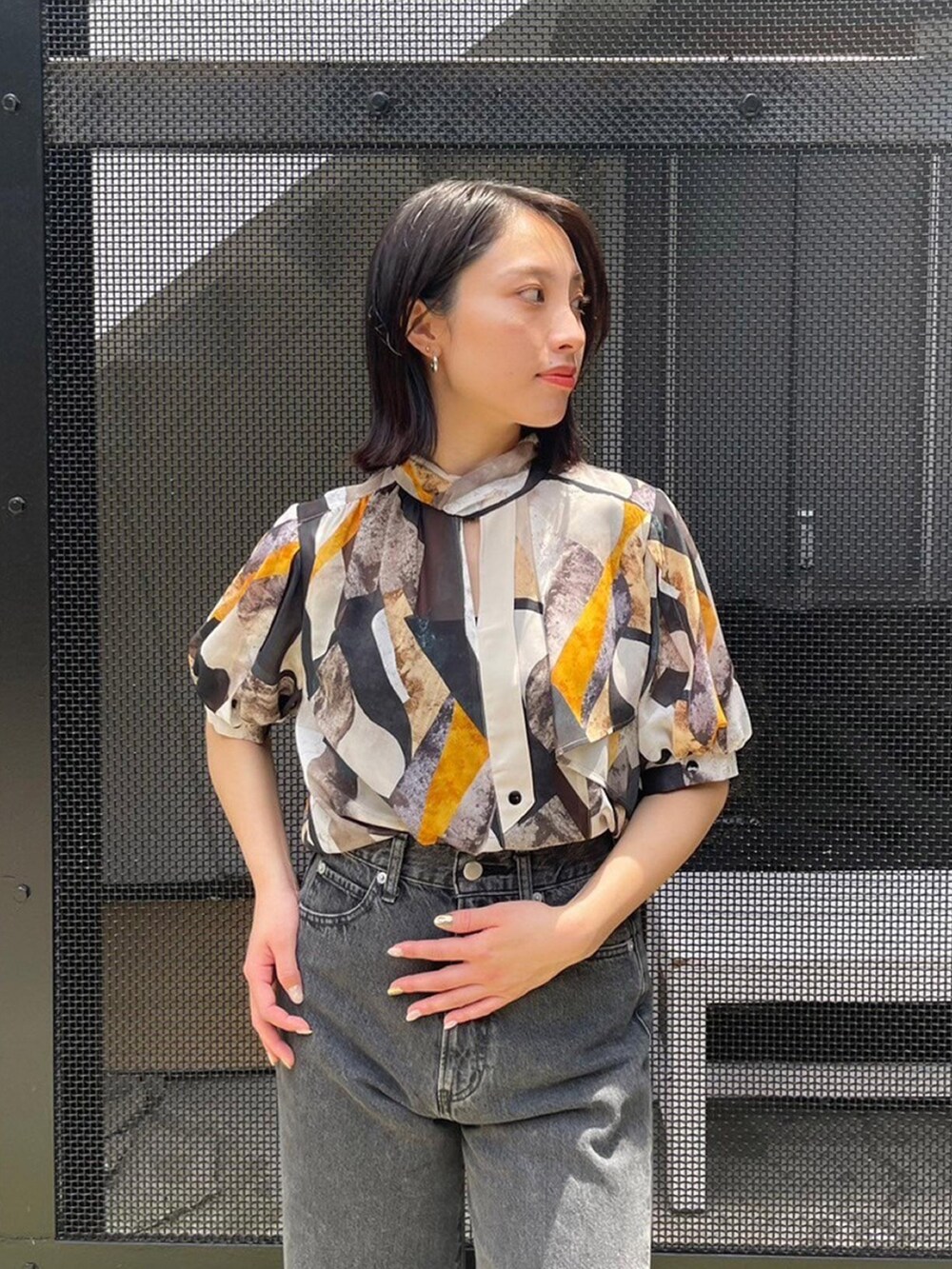 イエロー系のシャツ/ブラウス、ブラック系のデニムパンツを着用したレディースの春コーディネートの5枚目の写真