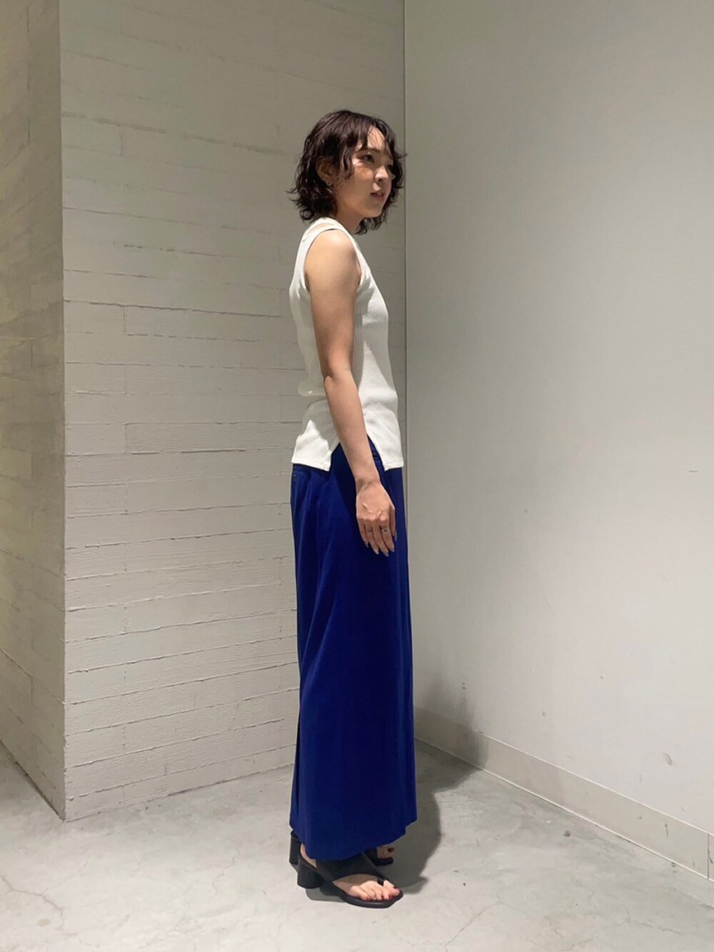 ホワイト系のタンクトップ、ブルー系のスカートを着用したレディースの夏コーディネートの2枚目の写真