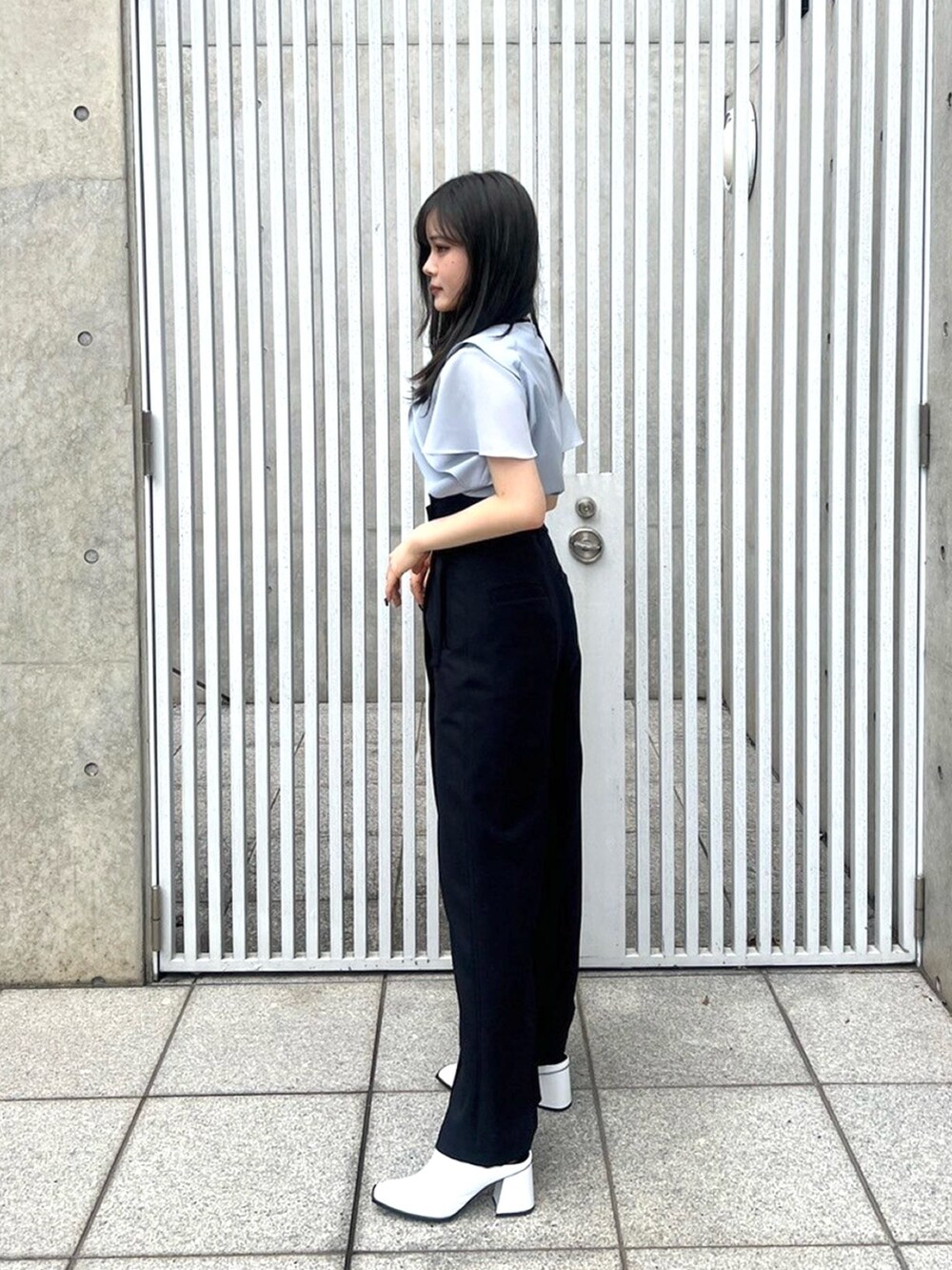 ブルー系のシャツ/ブラウス、ブラック系のスラックスを着用したレディースの春コーディネートの2枚目の写真