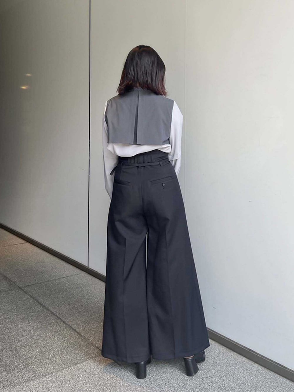 グレー系のシャツ/ブラウス、ブラック系のスラックスを着用したレディースの夏コーディネートの2枚目の写真