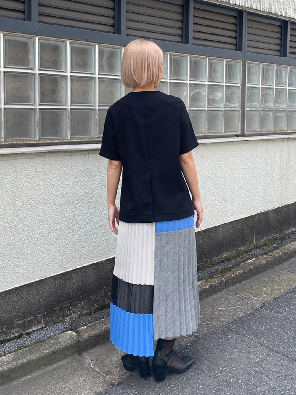 ブラック系のノーカラージャケット、ブルー系のスカートを着用したレディースの春コーディネートの3枚目の写真