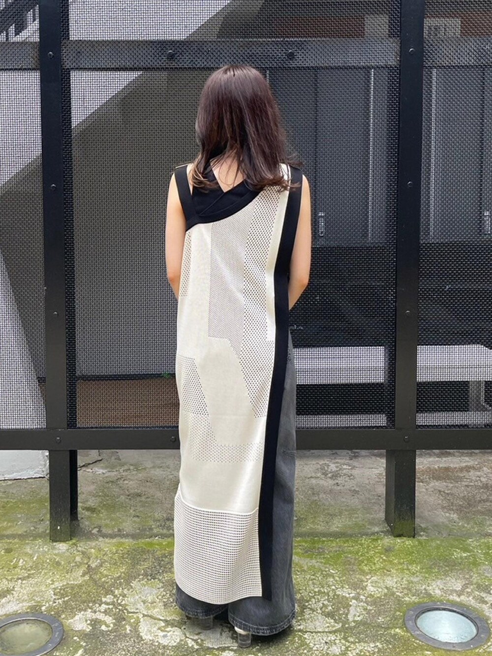 ホワイト系のワンピース、ブラック系のタンクトップ、ブラック系のデニムパンツを着用したレディースの春コーディネートの3枚目の写真