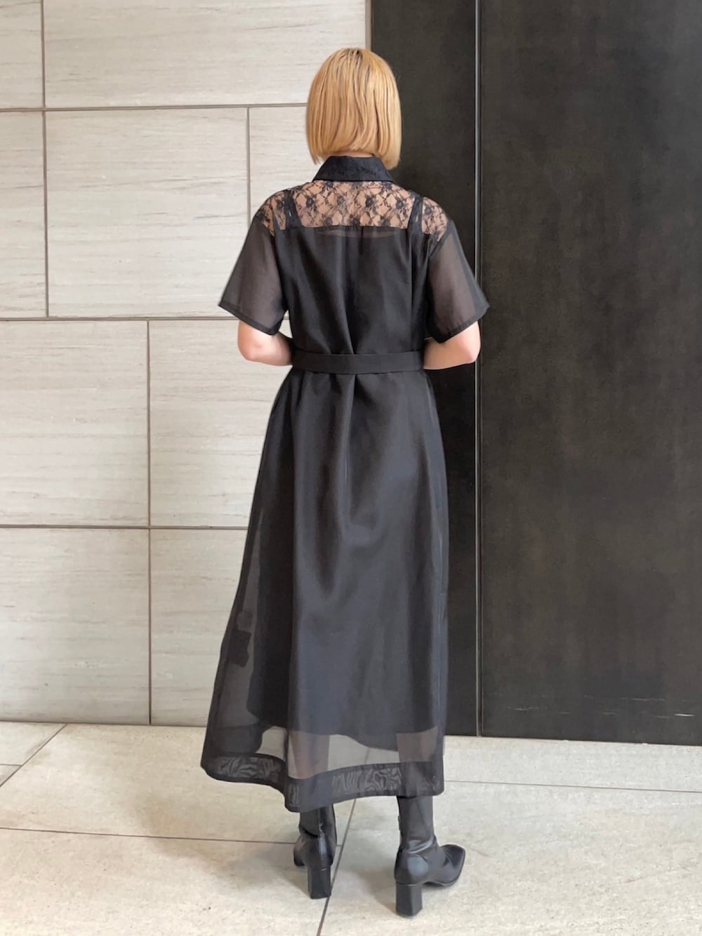 ブラック系のシャツワンピースを着用したレディースの春コーディネートの3枚目の写真