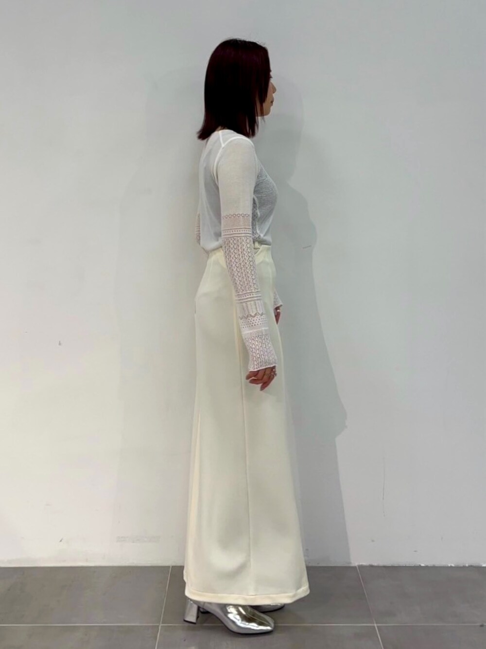 ホワイト系のニット/セーター、ホワイト系のスカートを着用したレディースの春コーディネートの4枚目の写真