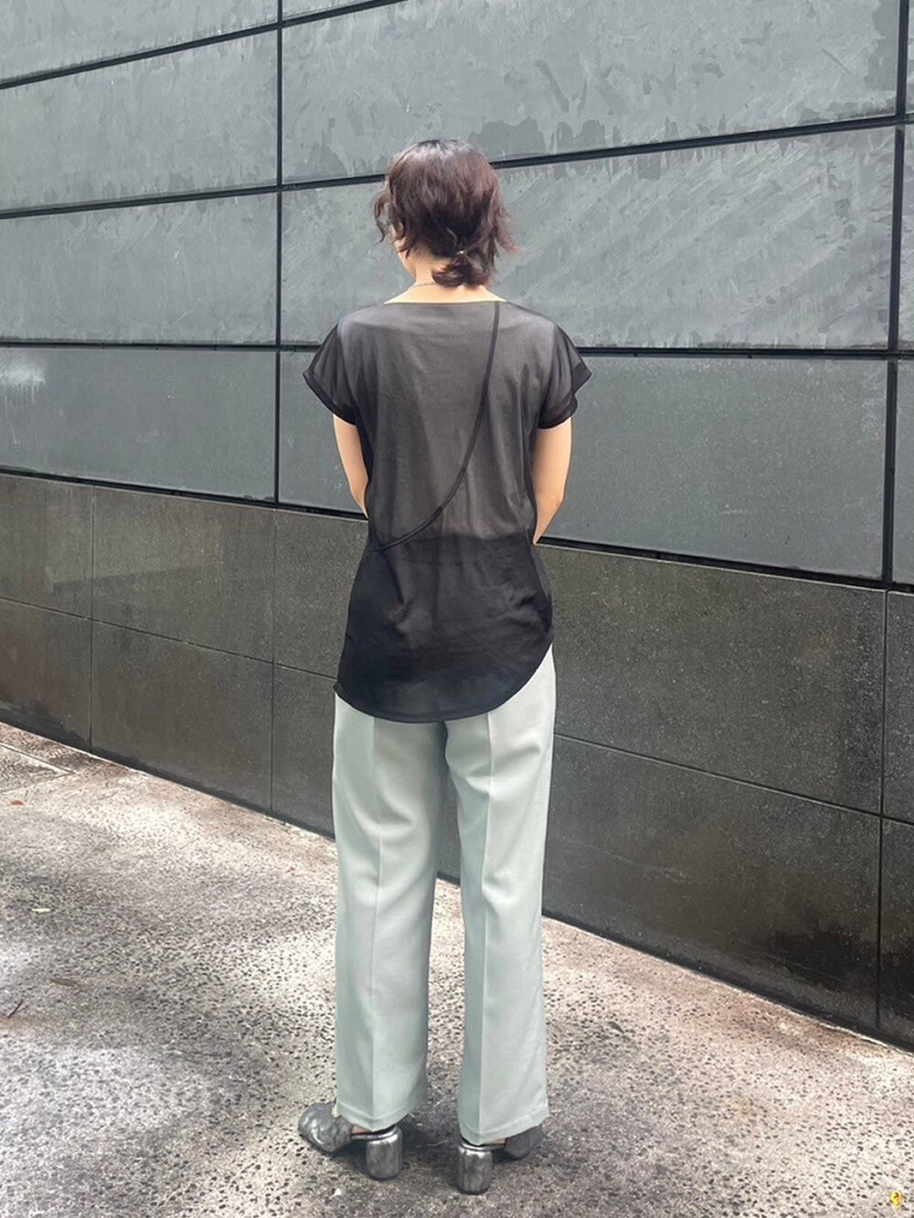 ブラック系のTシャツ/カットソー、グリーン系のスラックスを着用したレディースの夏コーディネートの3枚目の写真