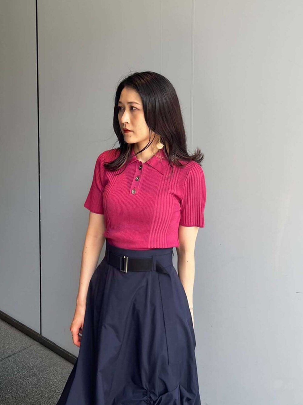 ピンク系のポロシャツ、ブルー系のスカートを着用したレディースの夏コーディネートの4枚目の写真