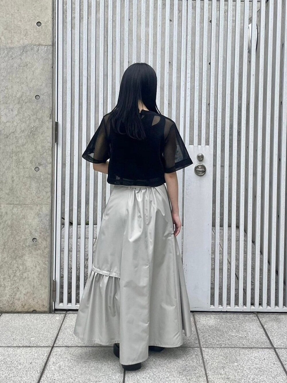 ブラック系のシャツ/ブラウス、ベージュ系のスカート、ブラック系のタンクトップを着用したレディースの春コーディネートの3枚目の写真