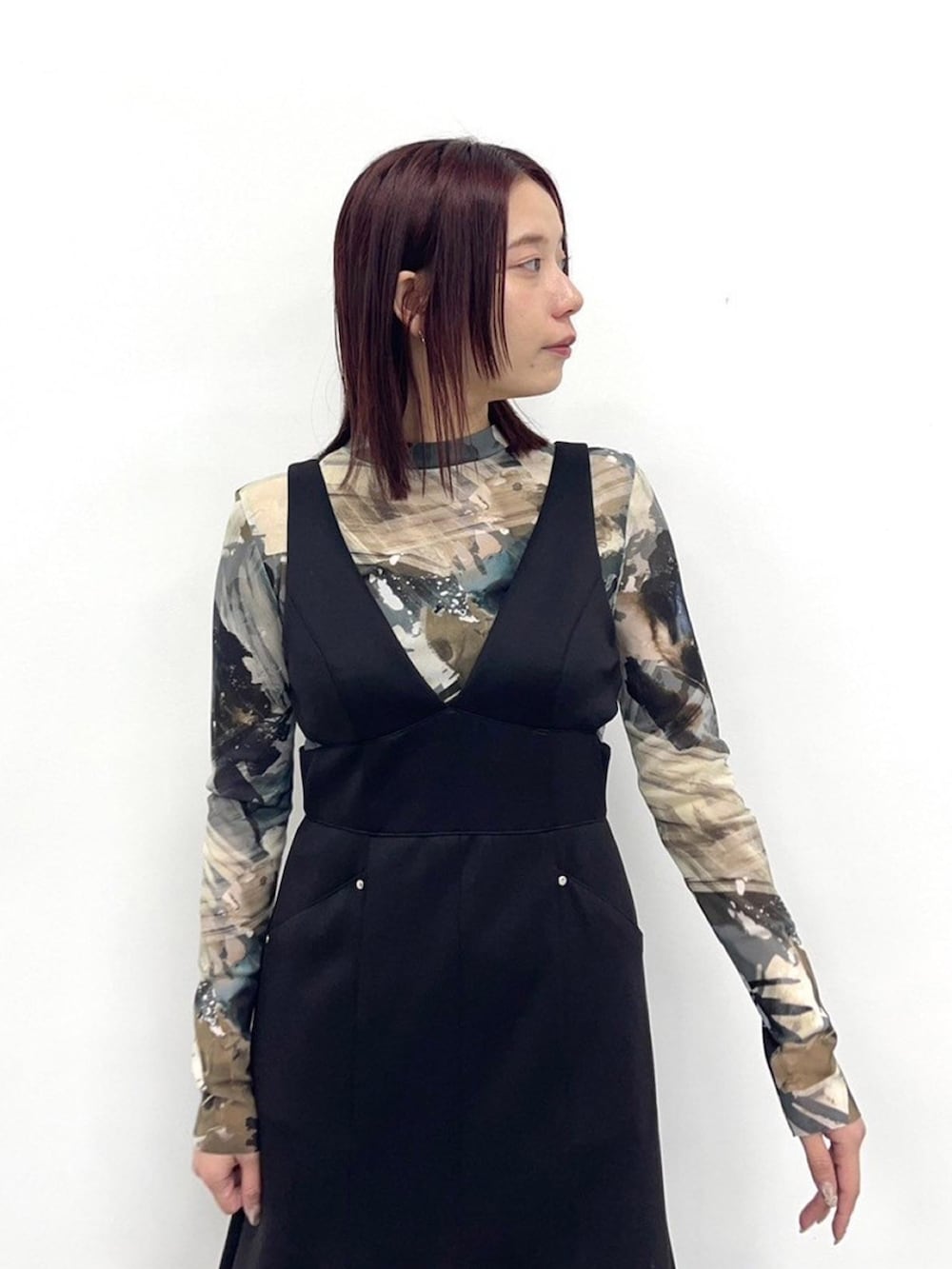 ブラック系のジャンパースカートを着用したレディースの春コーディネートの5枚目の写真