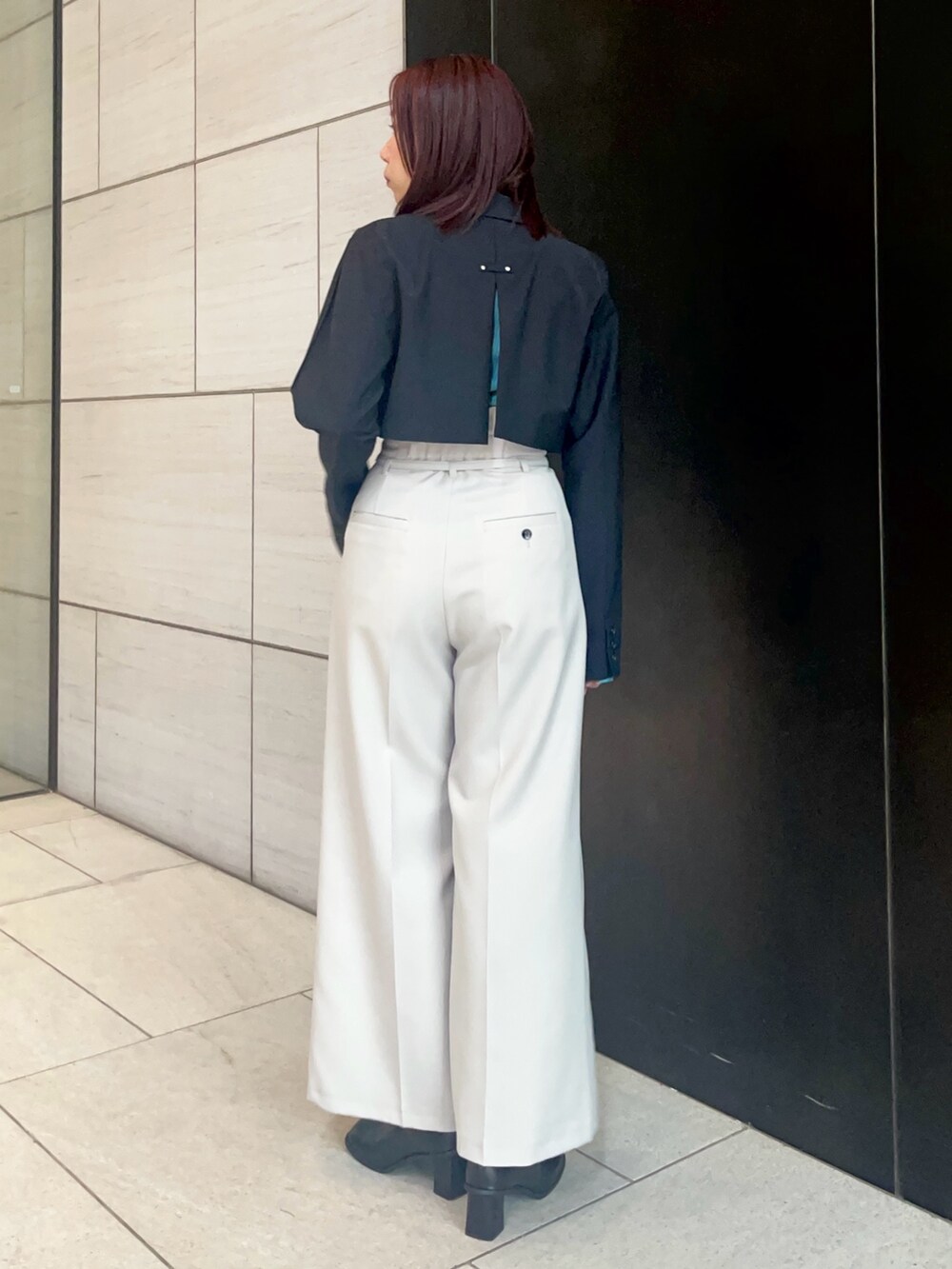 グレー系のスラックス、ブルー系のニット/セーターを着用したレディースの春コーディネートの3枚目の写真