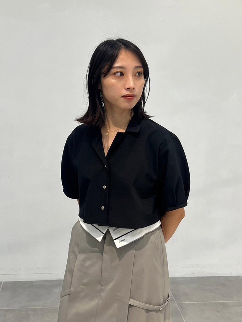 ブラック系のワンピース、グレー系のスカートを着用したレディースの秋コーディネートの4枚目の写真