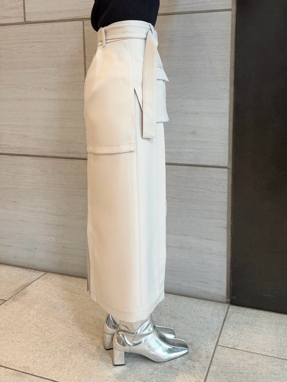 ベージュ系のスカート、ブラック系のニット/セーターを着用したレディースの春コーディネートの5枚目の写真