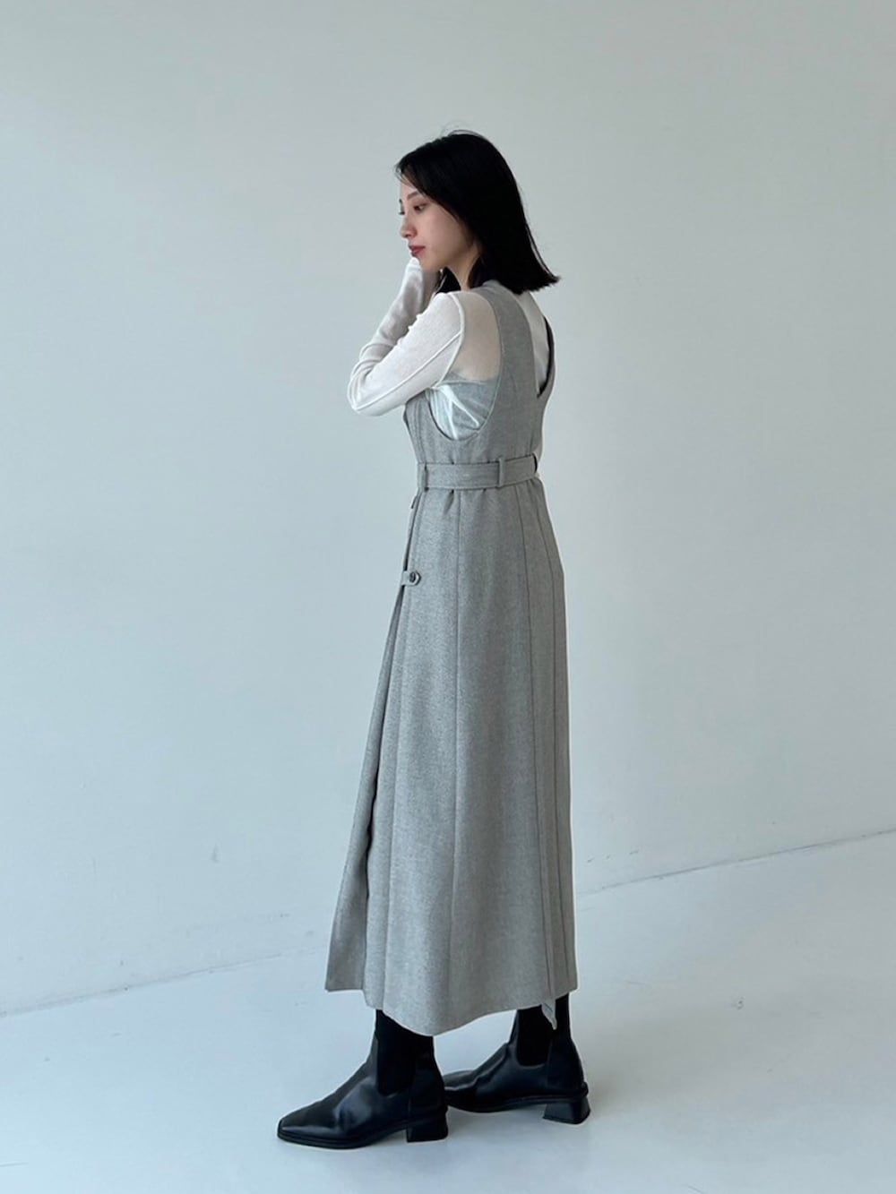 ブラック系のジャンパースカート、ベージュ系のTシャツ/カットソーを着用したレディースの秋コーディネートの2枚目の写真