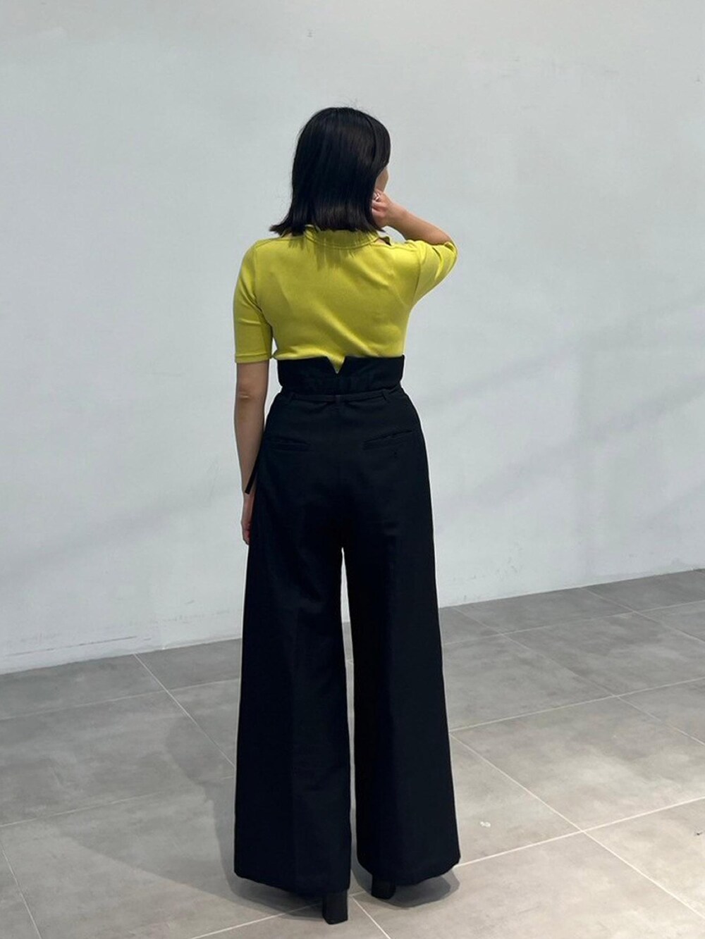 グリーン系のTシャツ/カットソー、ブラック系のスラックスを着用したレディースの秋コーディネートの3枚目の写真