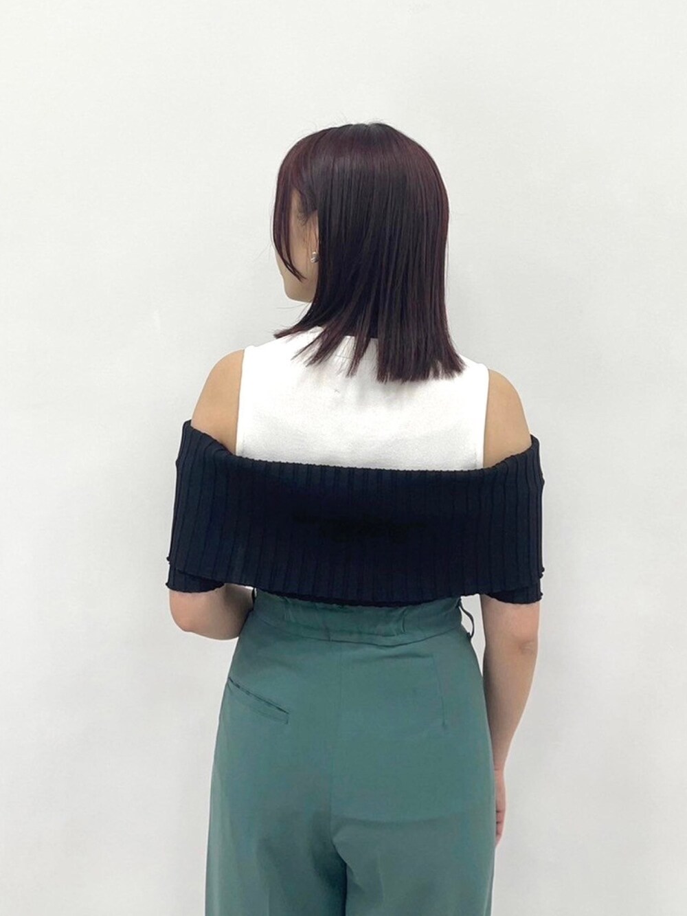 グリーン系のスラックス、ブラック系のニット/セーターを着用したレディースの春コーディネートの6枚目の写真