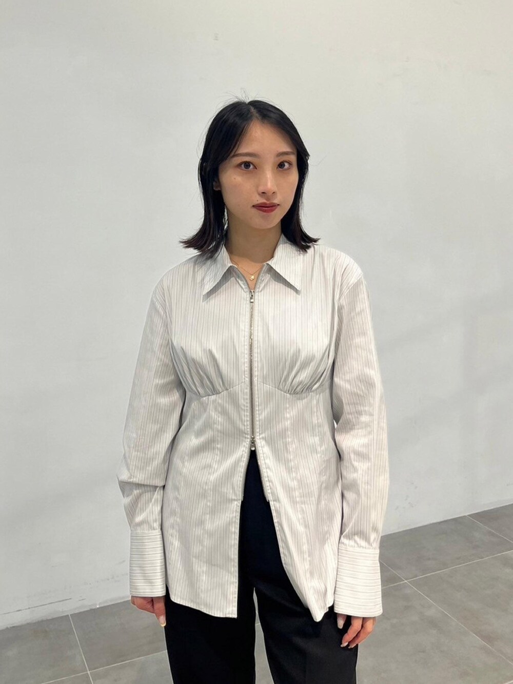 グレー系のシャツ/ブラウス、ブラック系のスラックスを着用したレディースの秋コーディネートの4枚目の写真