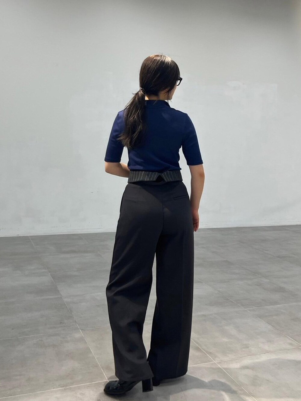 ブルー系のTシャツ/カットソー、グレー系のスラックスを着用したレディースの秋コーディネートの2枚目の写真