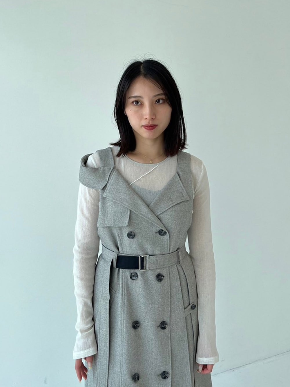 ブラック系のジャンパースカート、ベージュ系のTシャツ/カットソーを着用したレディースの秋コーディネートの3枚目の写真