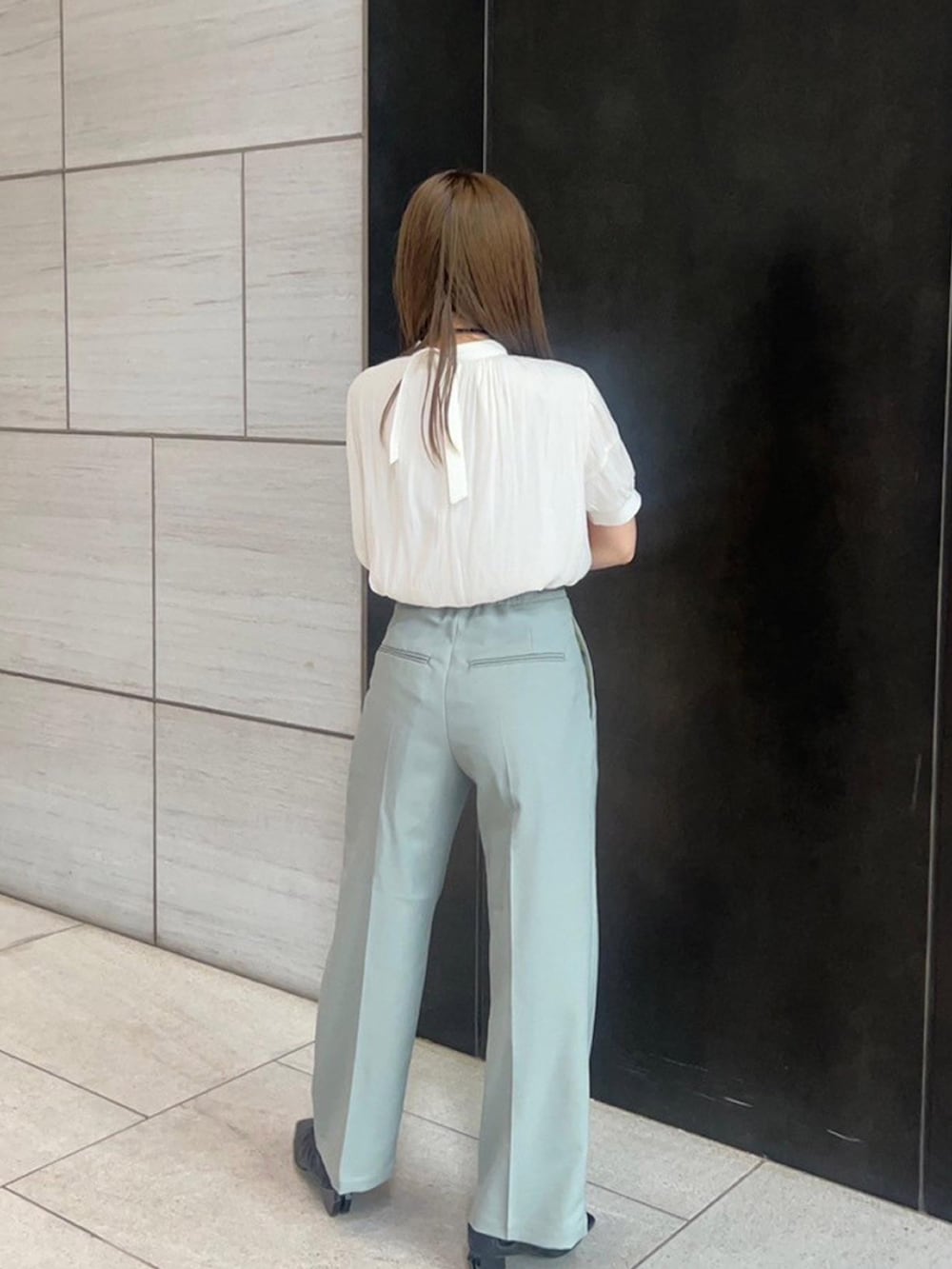 ベージュ系のシャツ/ブラウス、グリーン系のスラックスを着用したレディースの春コーディネートの3枚目の写真