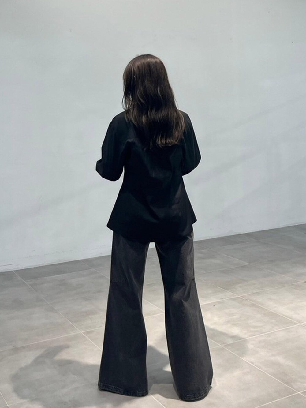 ブラック系のシャツ/ブラウス、ブラック系のデニムパンツを着用したレディースの秋コーディネートの3枚目の写真